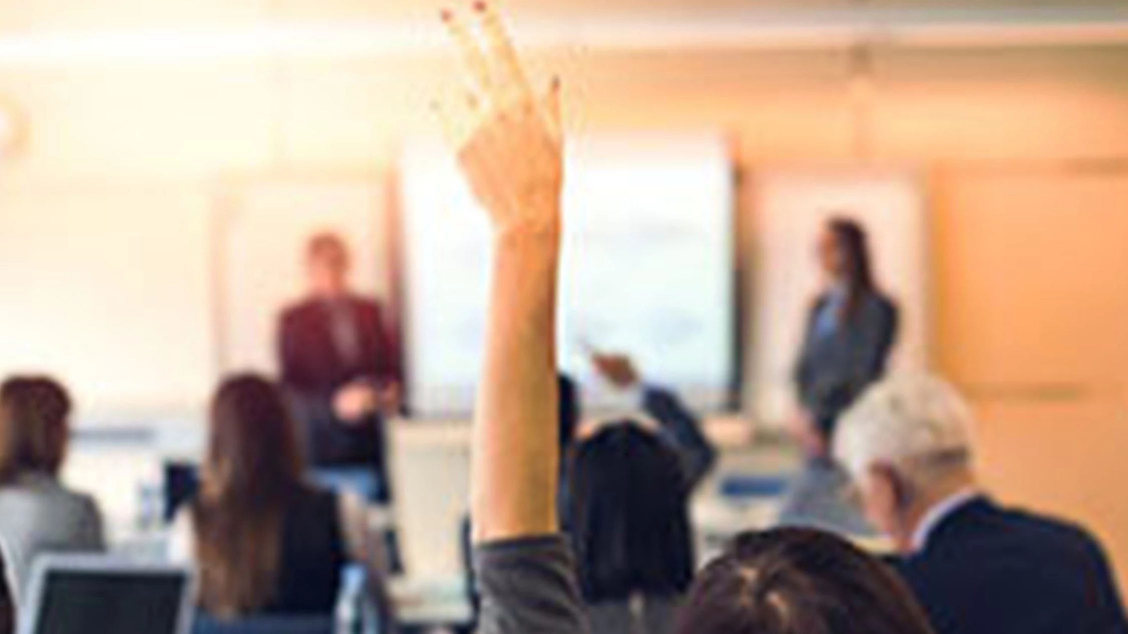 person raising hand in a meeting room